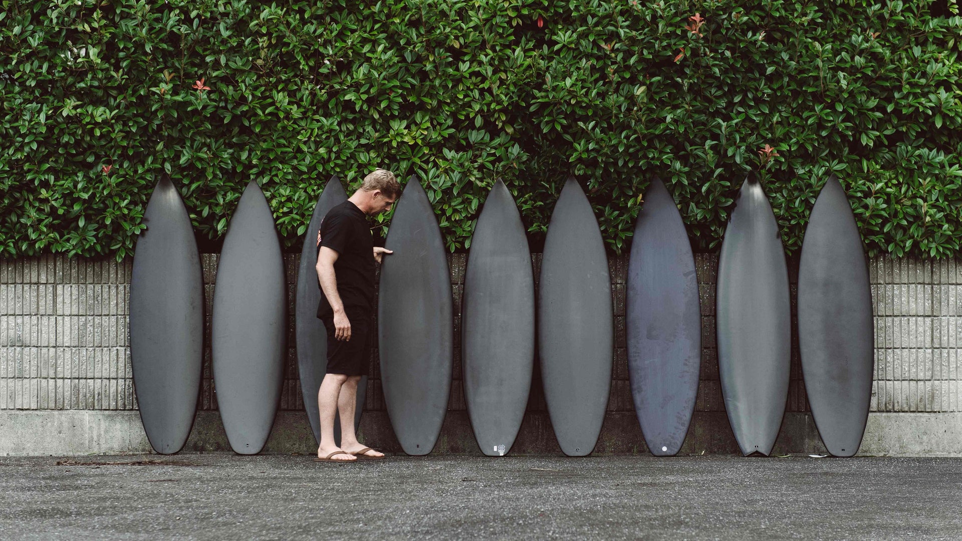 Mick Fanning admiring black surfboards