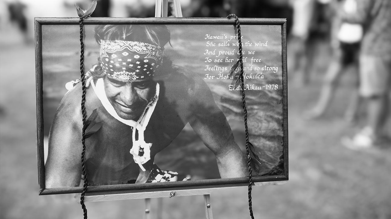 Black and white photo of a person with a bandana, framed with text, on a blurred background.