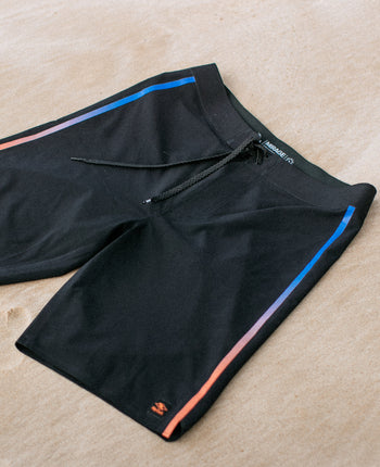 Black shorts with blue and orange accents on a beige surface