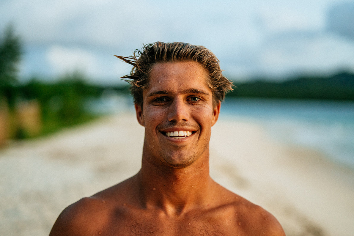 Man with sunburnt skin smiling on a beach