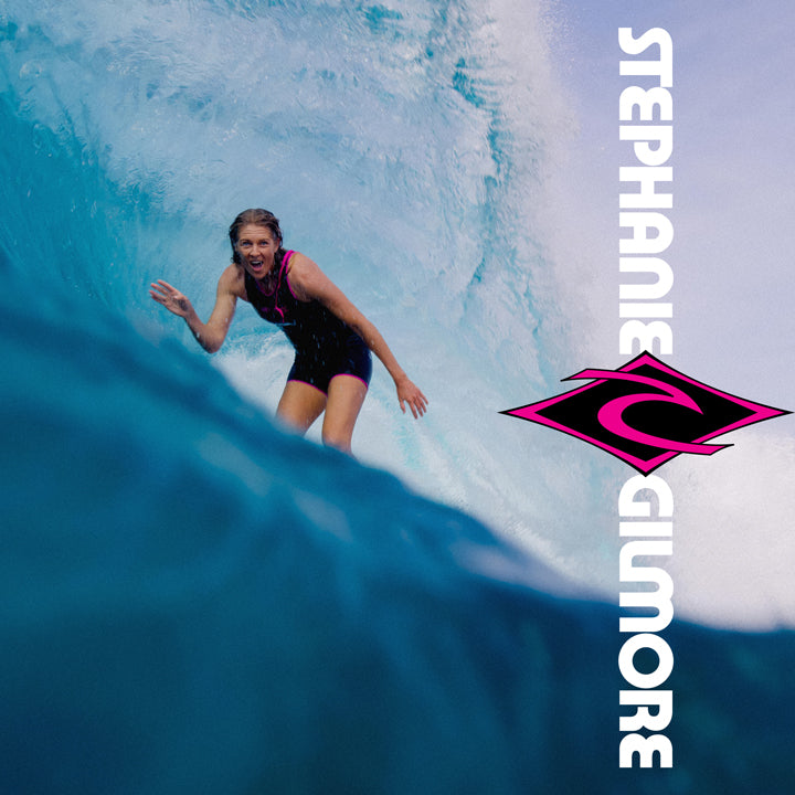Person surfing a wave with 'Stephanie Gilmore' branding on the right side.