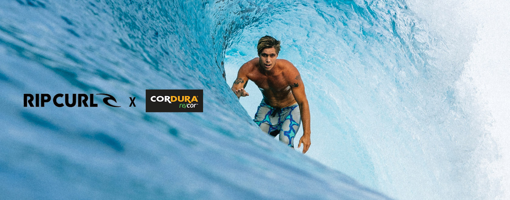 Man surfing through a wave with Rip Curl and Cordura logos.