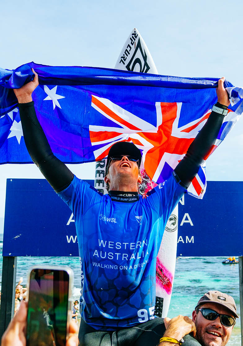 Person holding an Australian flag with a blue sky background