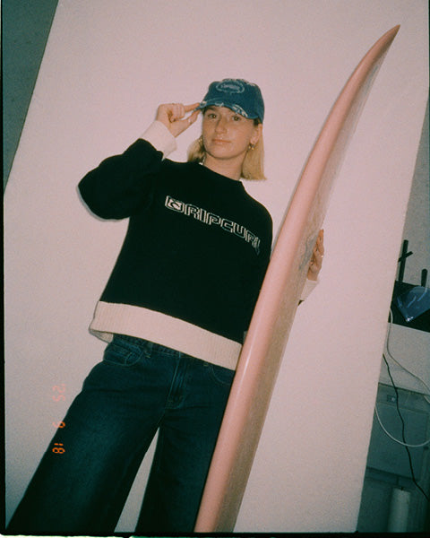 Rip Curl model wearing black knit jumper 